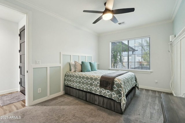 carpeted bedroom featuring ornamental molding and ceiling fan