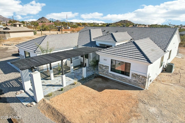 exterior space featuring cooling unit, a pergola, and a mountain view