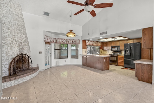 9839 W Utopia Rd, Peoria, AZ 85382 - kitchen with black appliances, brown cabinetry, light tile patterned floors, light countertops, and high vaulted ceiling
