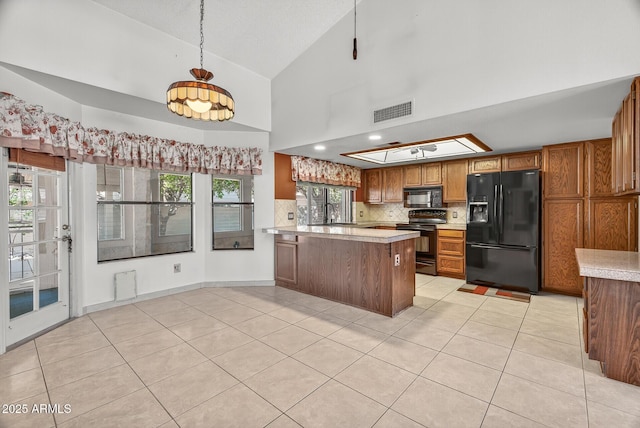 9839 W Utopia Rd, Peoria, AZ 85382 - kitchen with black appliances, brown cabinetry, light tile patterned floors, a peninsula, and light countertops