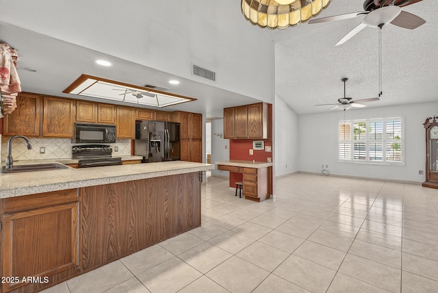 9839 W Utopia Rd, Peoria, AZ 85382 - kitchen with black appliances, ceiling fan, backsplash, light tile patterned floors, and brown cabinetry