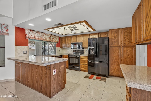 9839 W Utopia Rd, Peoria, AZ 85382 - kitchen featuring black appliances, a peninsula, brown cabinetry, decorative backsplash, and light tile patterned floors