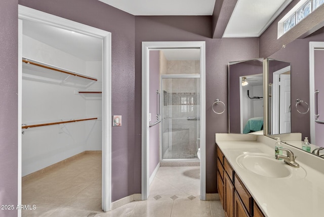 9839 W Utopia Rd, Peoria, AZ 85382 - bathroom featuring vanity, a stall shower, a walk in closet, and tile patterned floors