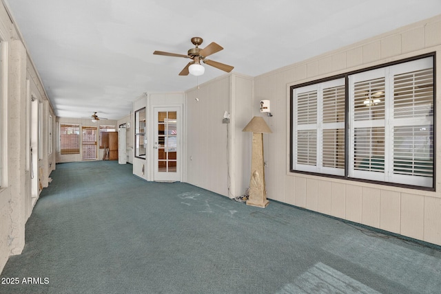 9839 W Utopia Rd, Peoria, AZ 85382 - unfurnished living room featuring ceiling fan, carpet floors, and wooden walls