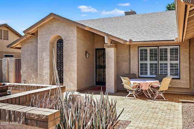 9839 W Utopia Rd, Peoria, AZ 85382 - property entrance with a patio, a shingled roof, a chimney, and stucco siding