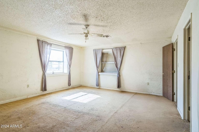 unfurnished room featuring ceiling fan, light colored carpet, and a textured ceiling