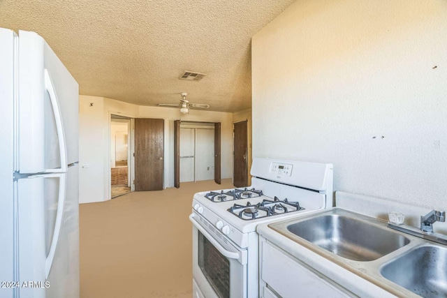 kitchen featuring a textured ceiling, white cabinets, white appliances, and sink