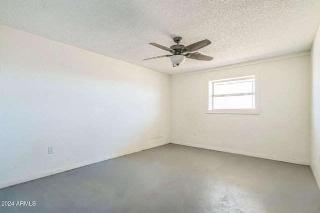 unfurnished room with a textured ceiling, concrete floors, and ceiling fan