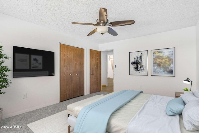 carpeted bedroom featuring a textured ceiling, a closet, and ceiling fan