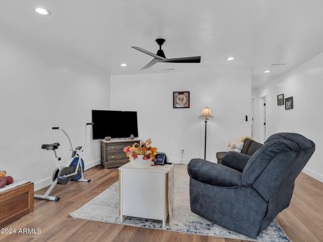 living room featuring ceiling fan and light hardwood / wood-style floors