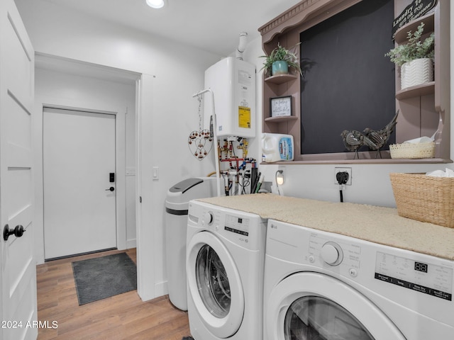 laundry area featuring light hardwood / wood-style floors, tankless water heater, and washer and dryer