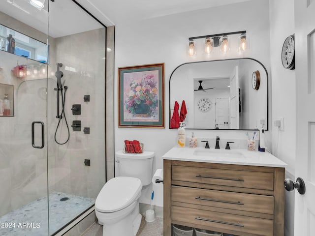 bathroom with ceiling fan, vanity, toilet, tile patterned flooring, and a shower with door