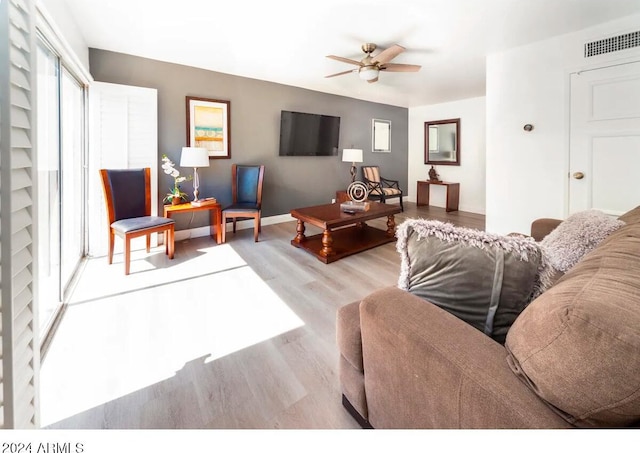 living room with light hardwood / wood-style flooring and ceiling fan