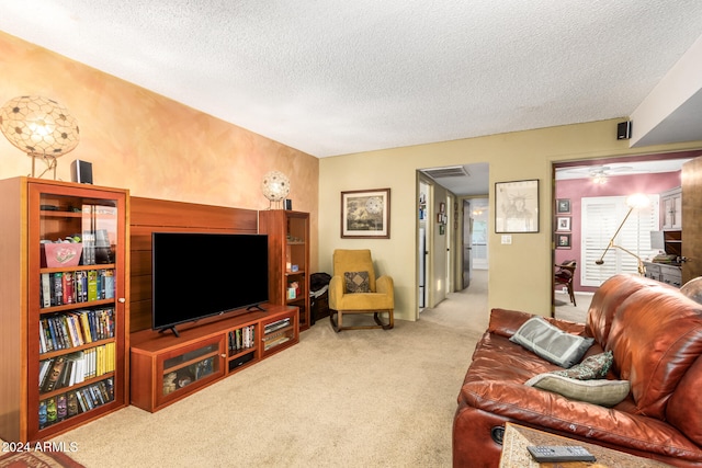 living room with light colored carpet, a textured ceiling, and ceiling fan