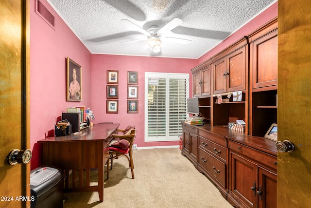 carpeted office space featuring ceiling fan and a textured ceiling