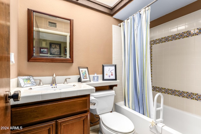 full bathroom featuring vanity, toilet, a skylight, and shower / bath combination with curtain