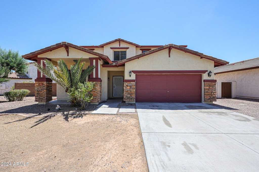 view of front of home featuring a garage, concrete driveway, stone siding, and stucco siding