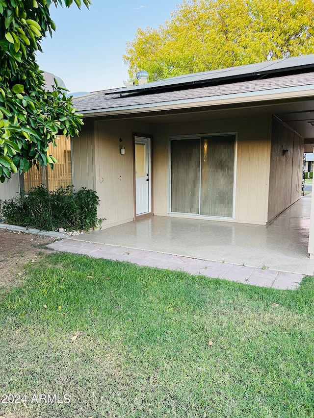 view of exterior entry with a patio area and a yard