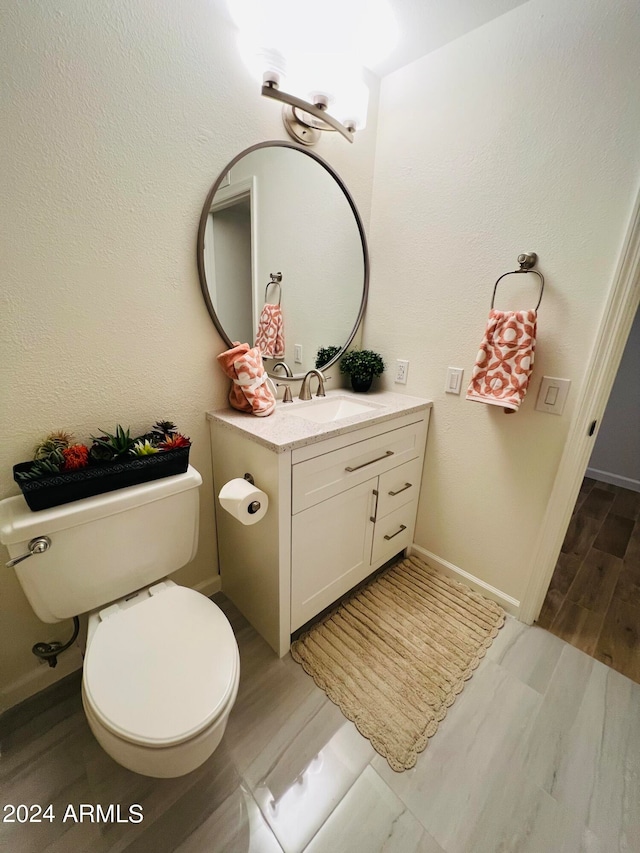 bathroom featuring hardwood / wood-style floors, vanity, and toilet