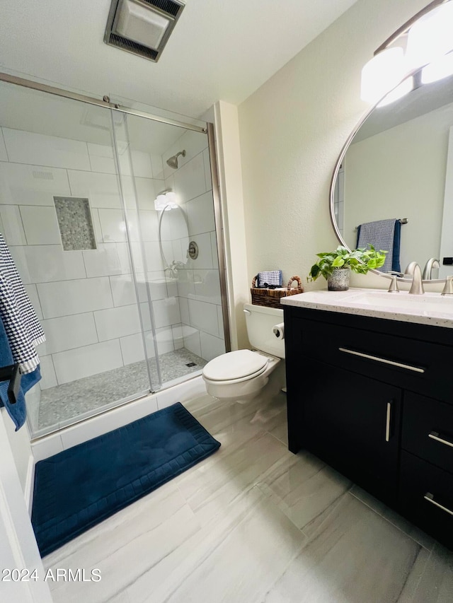 bathroom with vanity, toilet, and an enclosed shower