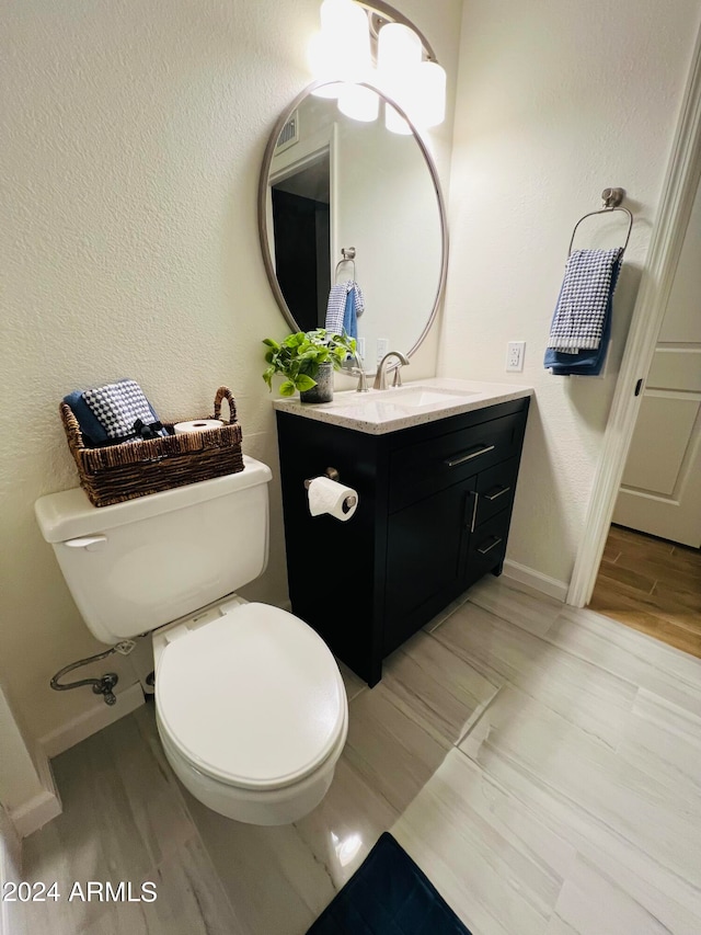 bathroom featuring hardwood / wood-style floors, vanity, and toilet