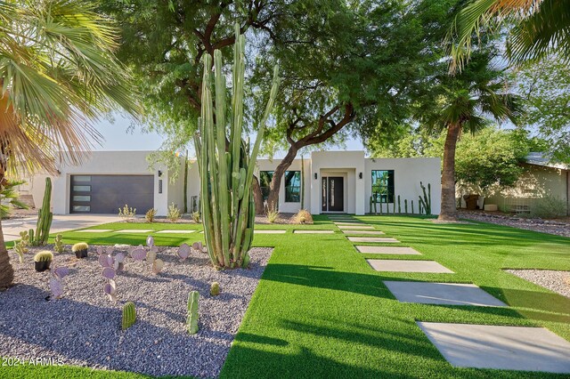 view of front of property featuring a front yard and a garage