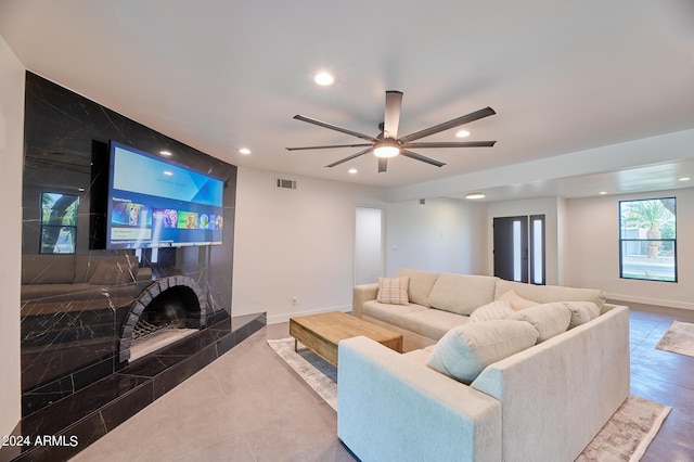 living room featuring ceiling fan and a fireplace