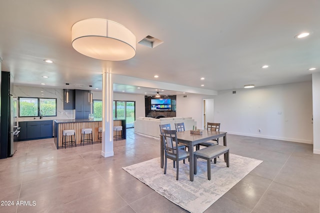 tiled dining space featuring ceiling fan and sink