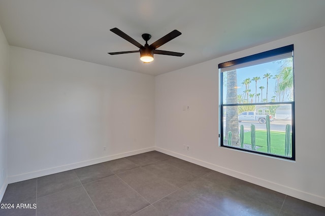 spare room featuring tile patterned flooring, a wealth of natural light, and ceiling fan