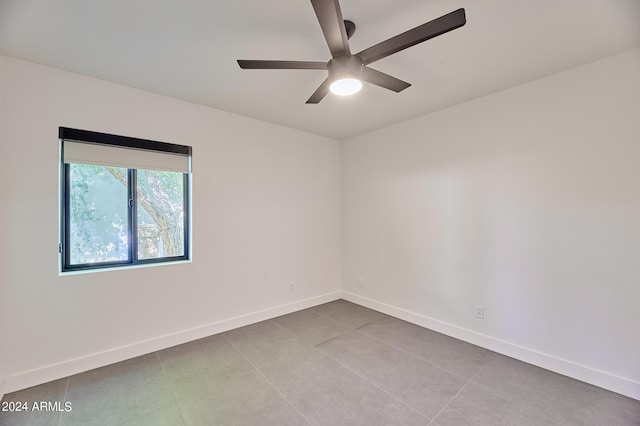 tiled spare room with ceiling fan