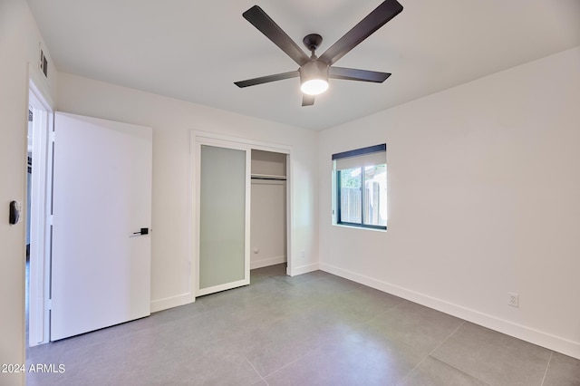 unfurnished bedroom with ceiling fan and a closet