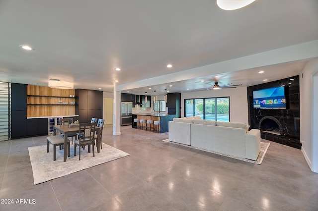 interior space featuring a tile fireplace and ceiling fan