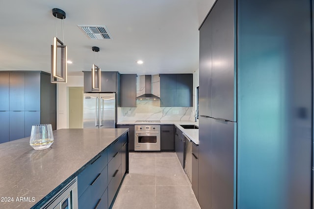 kitchen with pendant lighting, light tile patterned floors, stainless steel appliances, decorative backsplash, and wall chimney exhaust hood