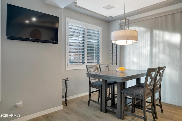 dining space with wood-type flooring