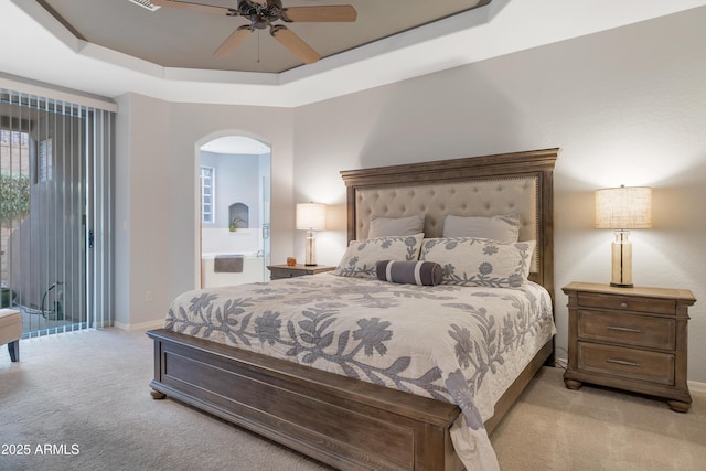 carpeted bedroom featuring a raised ceiling and ceiling fan