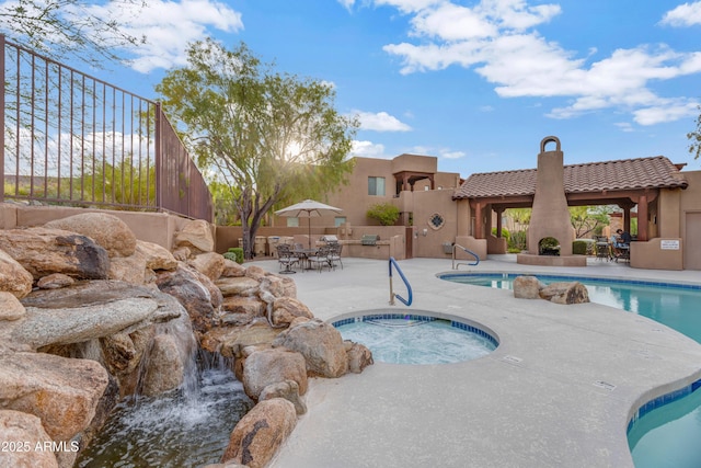 view of swimming pool with a gazebo, a patio area, a community hot tub, and a fireplace