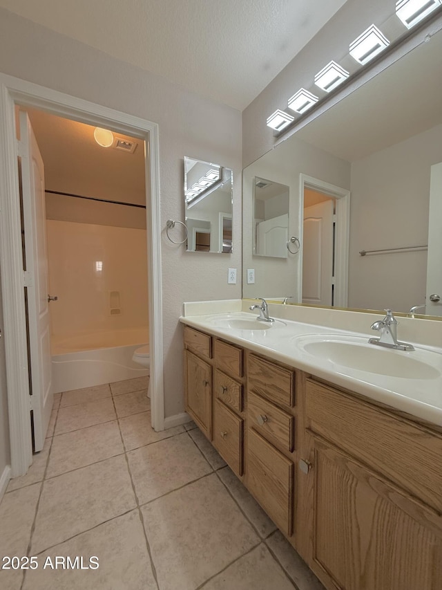 full bath featuring tile patterned floors, double vanity, toilet, and a sink