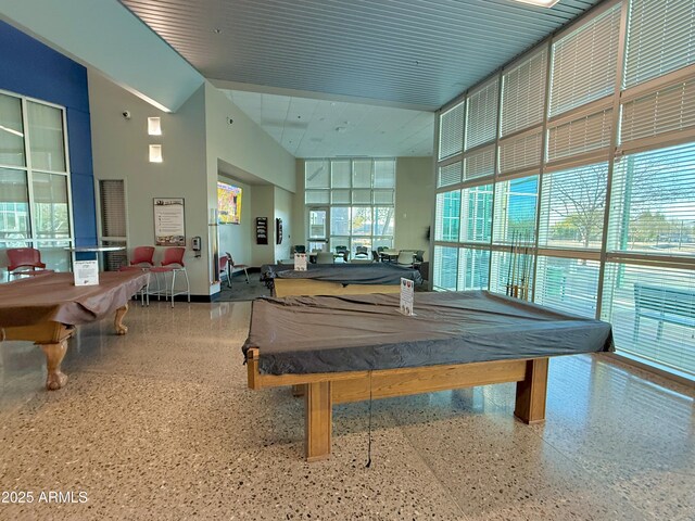 recreation room featuring billiards, a high ceiling, and speckled floor