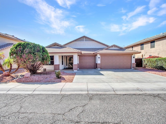 view of front of house featuring a tile roof, stucco siding, concrete driveway, and a garage