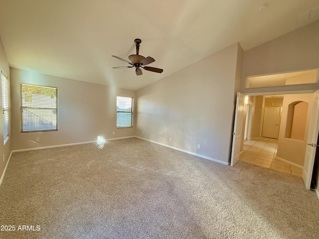 unfurnished room with baseboards, light carpet, a ceiling fan, and vaulted ceiling