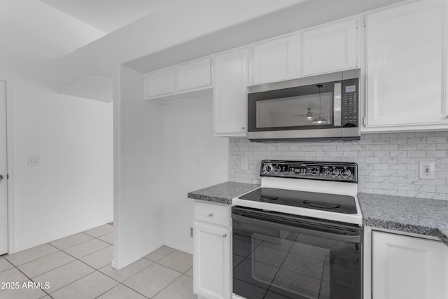 1405 E Chicago Cir, Chandler, AZ 85225 - kitchen with range with electric stovetop, stainless steel microwave, light tile patterned flooring, white cabinets, and tasteful backsplash