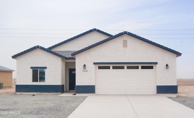 view of front of home featuring a garage, driveway, a tiled roof, cooling unit, and stucco siding