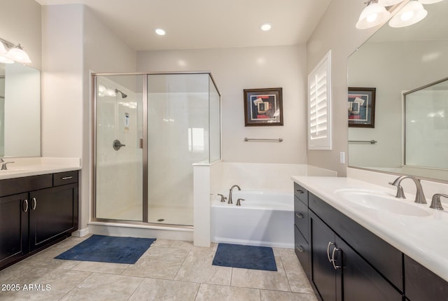 full bathroom featuring two vanities, a stall shower, a sink, tile patterned flooring, and a bath