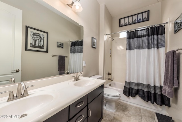 bathroom featuring double vanity, shower / tub combo, toilet, and a sink