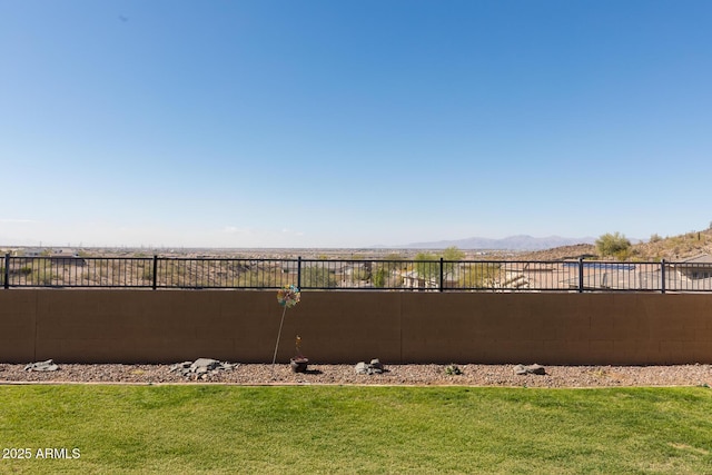 view of yard featuring fence and a mountain view