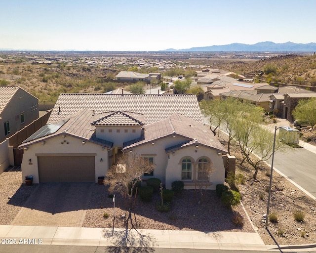 mediterranean / spanish-style house featuring a mountain view, a garage, stucco siding, and decorative driveway