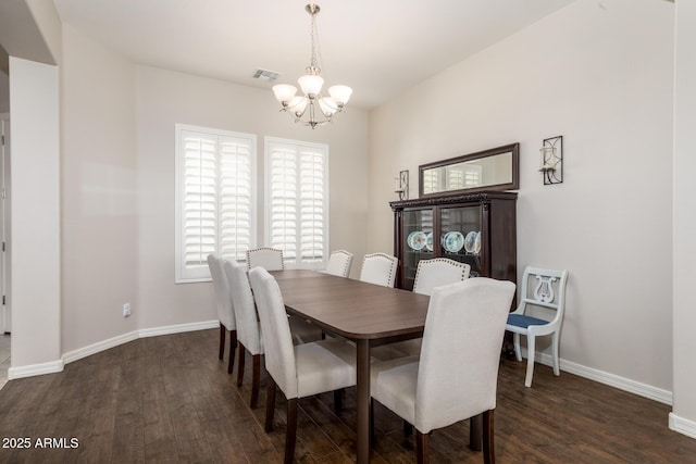 dining area featuring dark wood-style floors, visible vents, baseboards, and an inviting chandelier