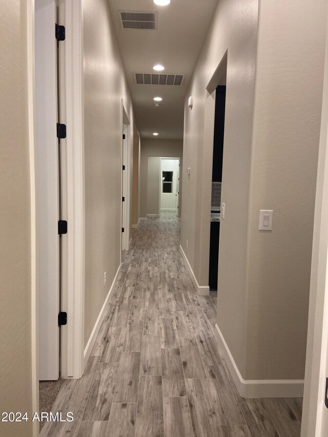 corridor with light hardwood / wood-style flooring