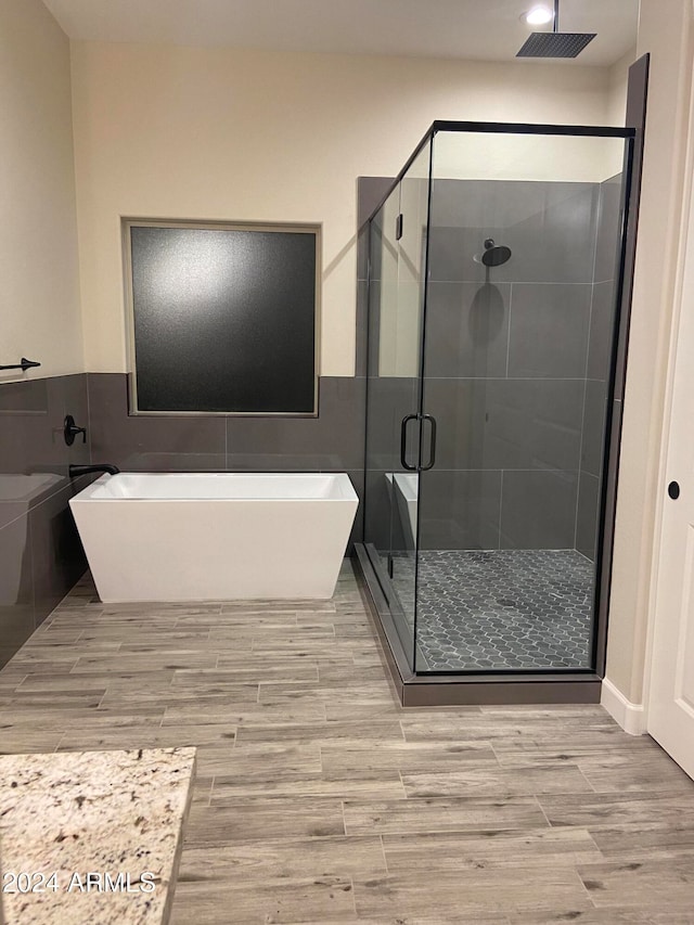 bathroom with plus walk in shower and hardwood / wood-style flooring