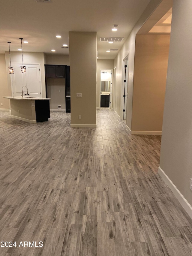 unfurnished living room featuring sink and hardwood / wood-style floors